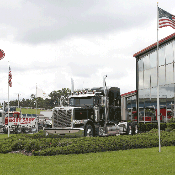 Waukesha Building front with flag pole with black Peterbilt 389